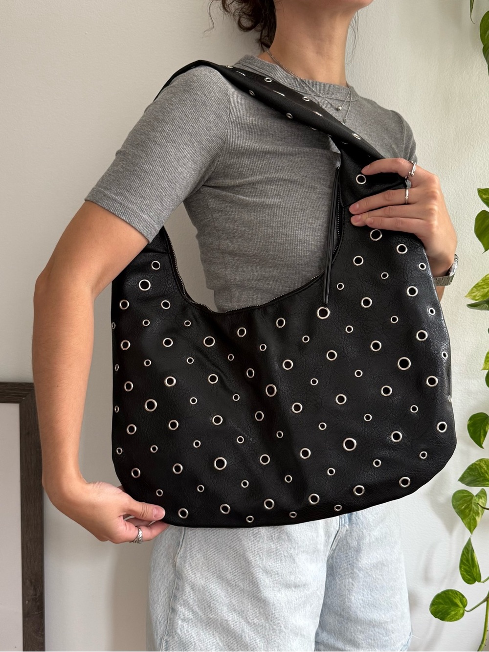 Black faux leather shoulder bag with metal eyelets